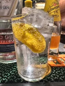 Mini gin tonic en vaso sevilla con piel de limón en la barra de Leinerhaus