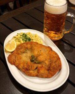 Schnitzel al estilo vienés con ensalada de patata alemana y jarra de cerveza
